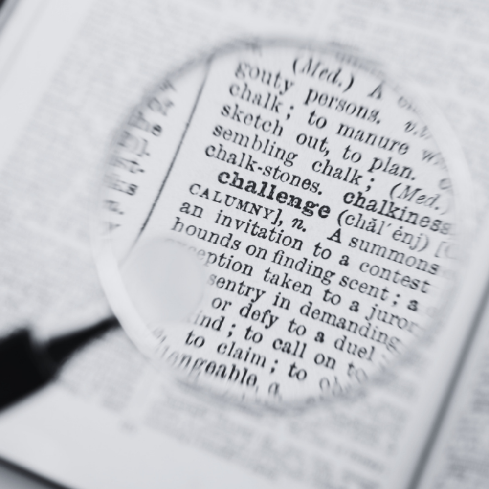 Vergrootglas die het woord 'challenge' in het woordenboek uitvergroot